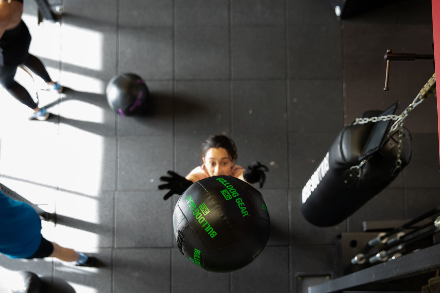 Someone exercising with a medicine ball in a dimly lit gym space during business branding photoshoot.