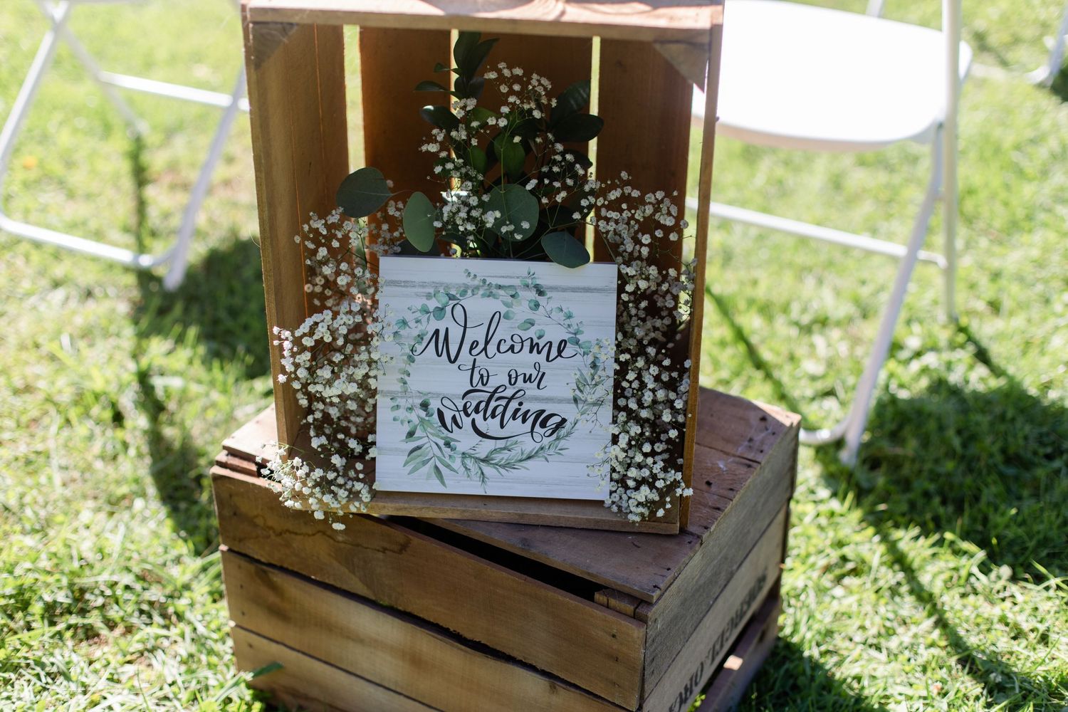 Elegant wedding signs and decor arranged in an outdoor garden setting.