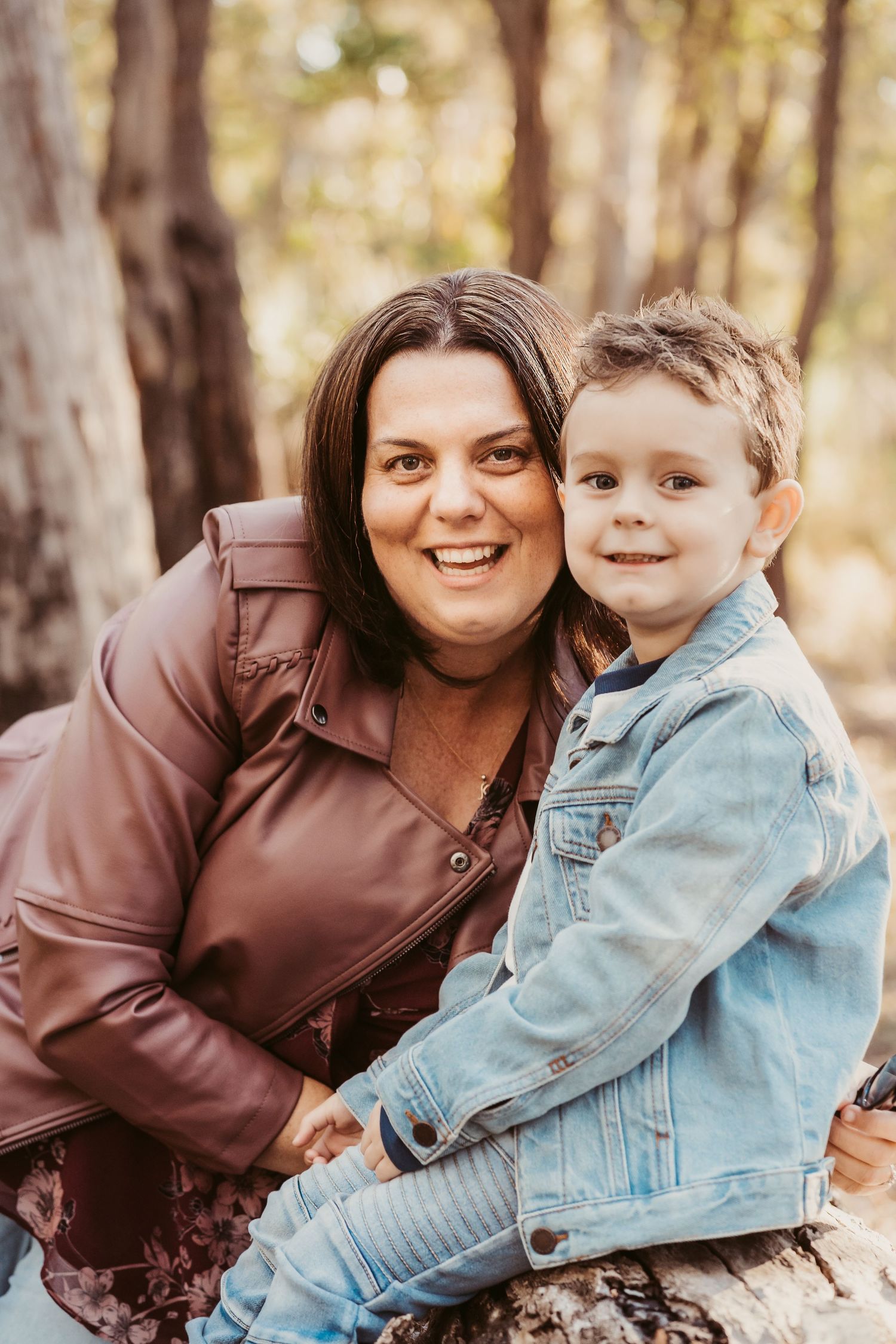 Warm autumn portraits of parent and child in matching brown and denim jackets outdoors.