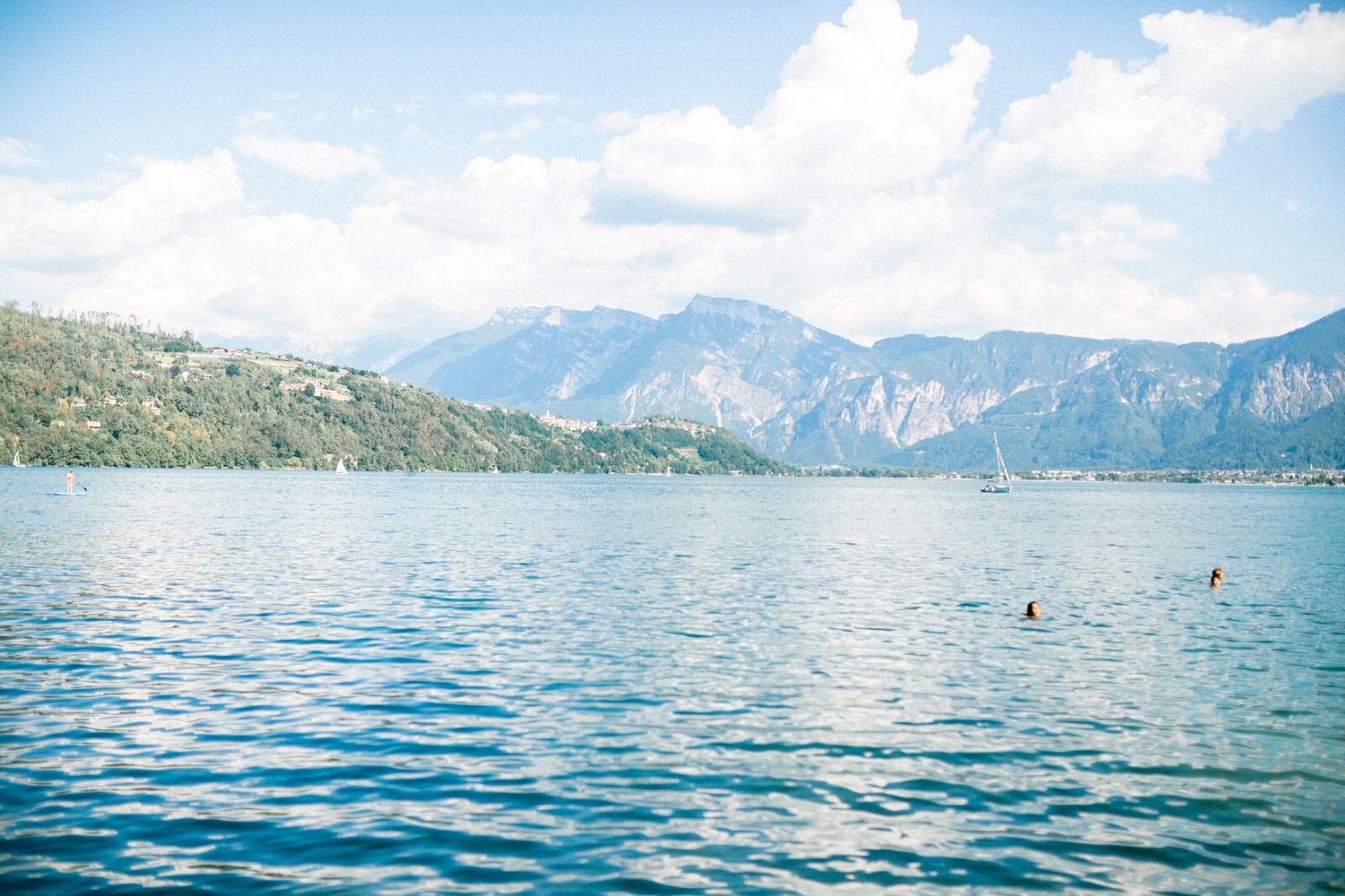 Serene mountain lake surrounded by peaks with crystal clear blue waters.