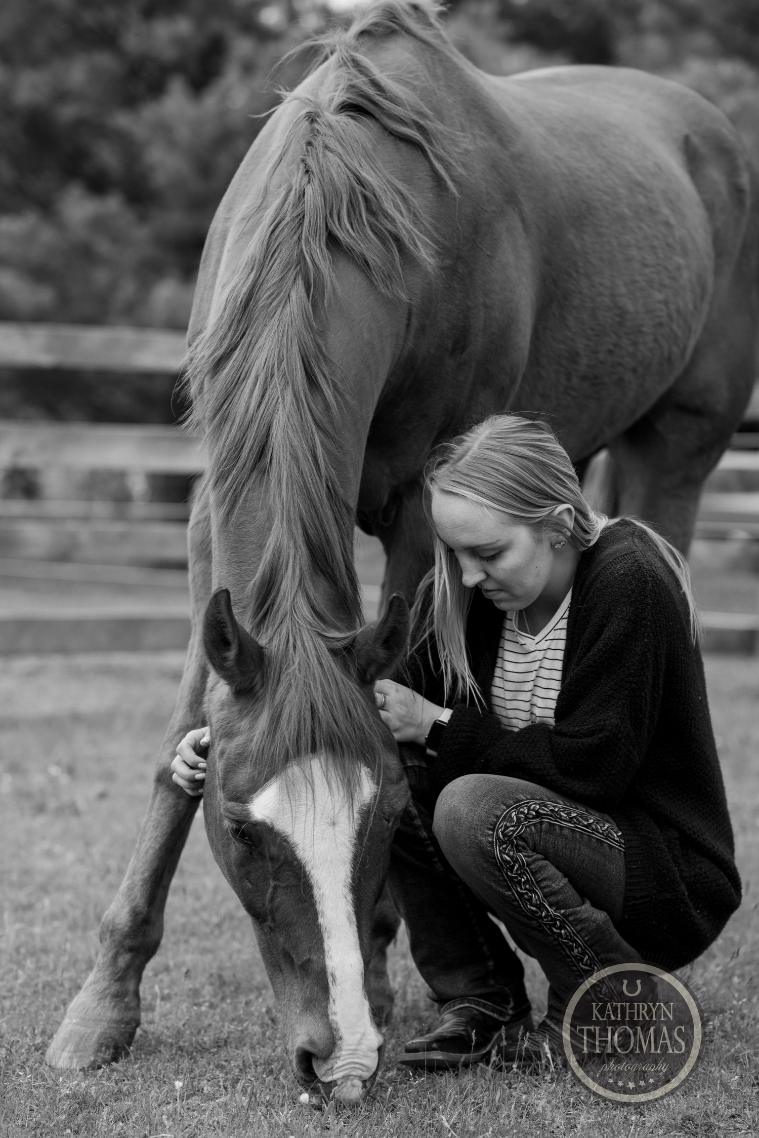 A horse bows its head down while being petted in a peaceful outdoor setting.