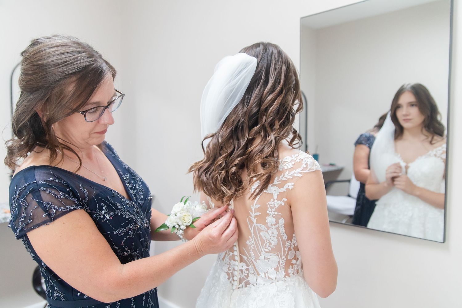 Getting ready sequence showing final dress preparations with navy blue bridesmaid details.