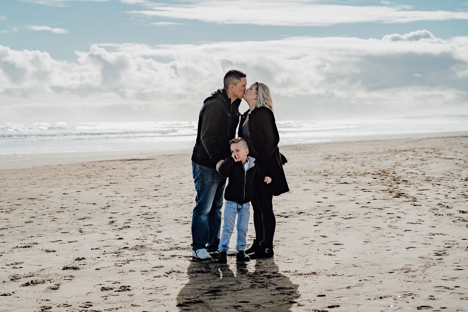 Mum and Dad kiss and their son is unaware of what is going on.