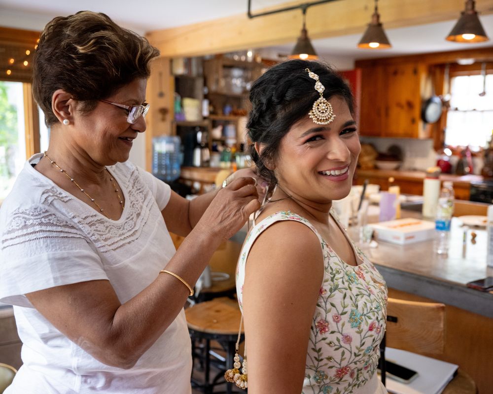 Candid moments captured during wedding day preparations in a warmly lit room.