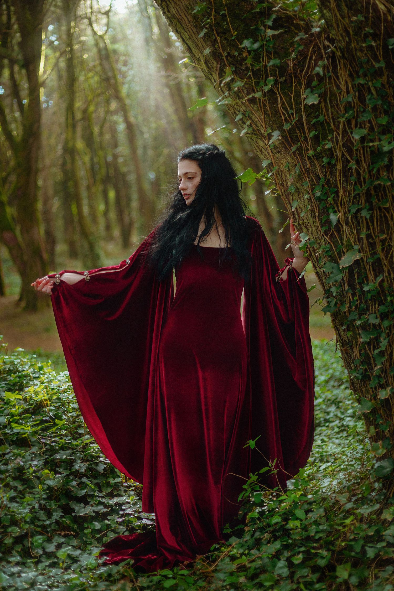 mulher feiticeira princesa medieval vestido veludo vermelho em floresta árvores heras encantada fantasia
