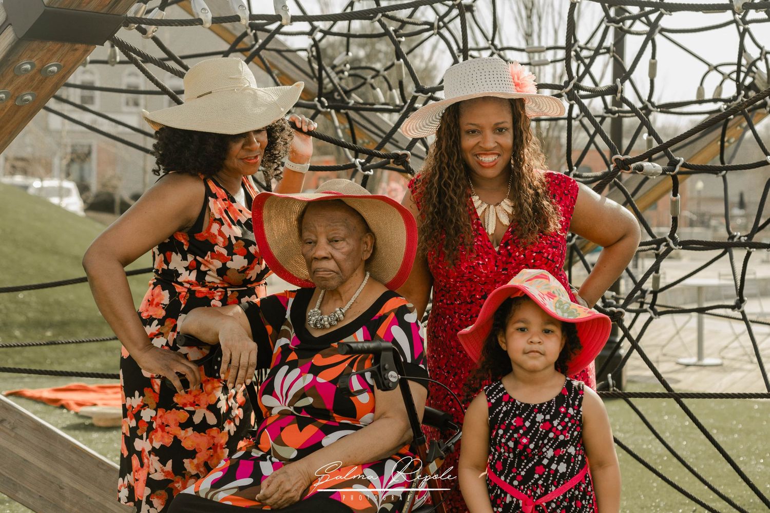 Group wearing coordinated floral and red outfits pose together outdoors.
