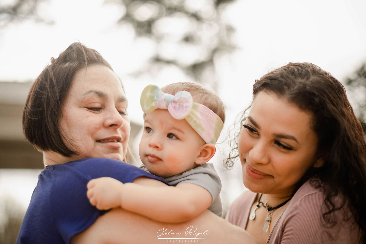 Candid lifestyle portrait of people sharing tender moments outdoors in soft lighting.