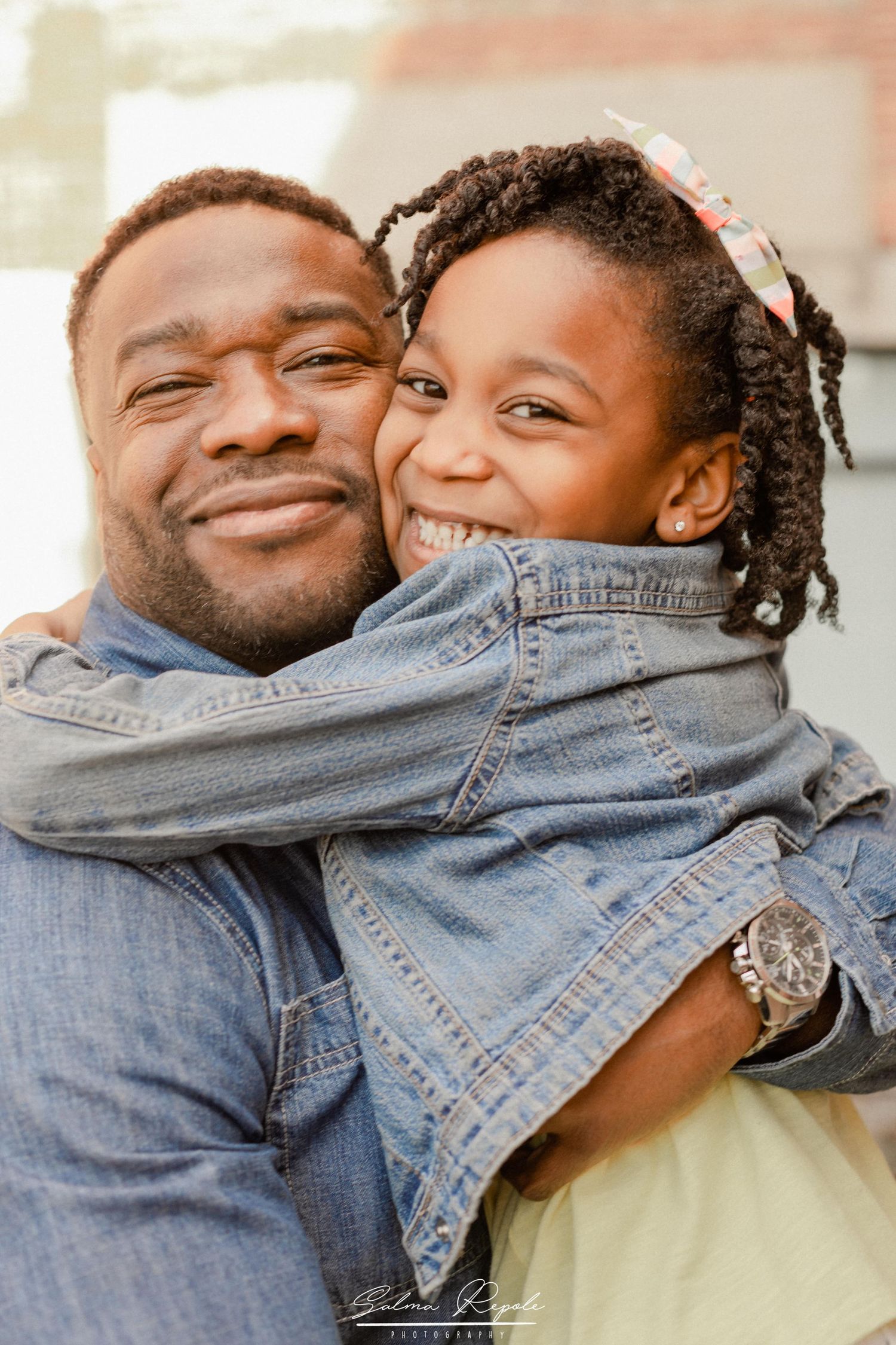 Tender moment captured between two people wearing denim in warm natural light.