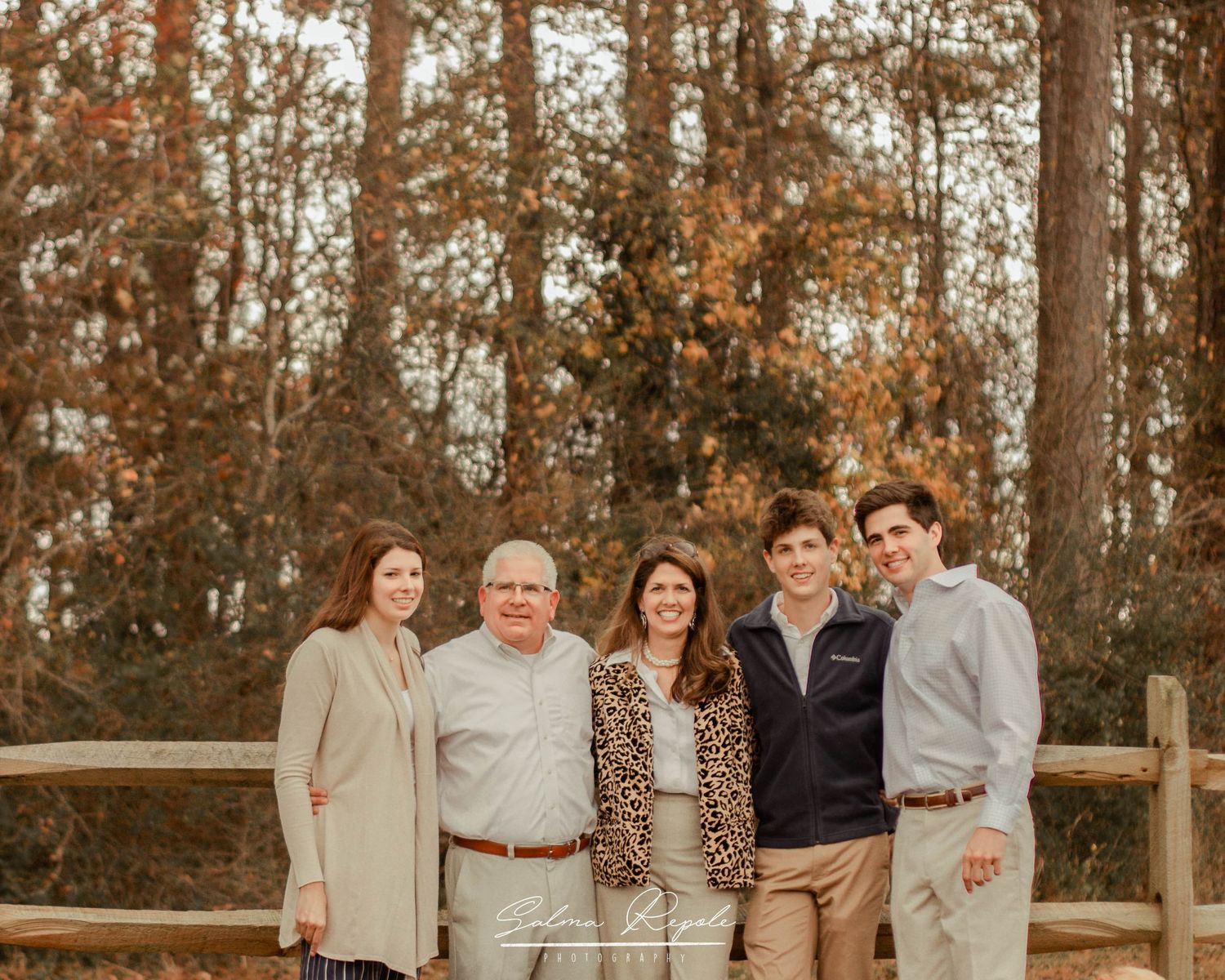 Multi-generational family photo session in an autumn woodland setting.