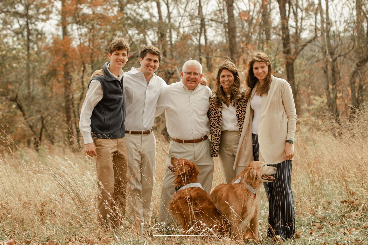 Extended family gathering outdoors in coordinated neutral tones for a group photo.