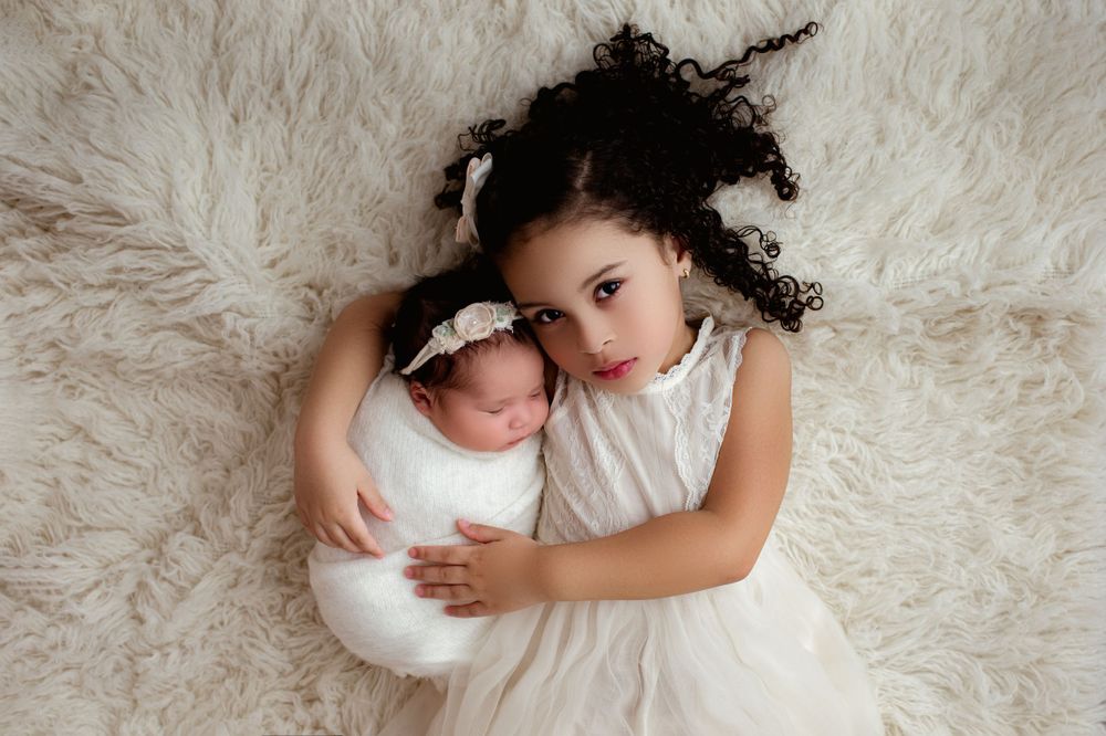 newborn baby girl with her older sister at their family photo session in columbus ohio