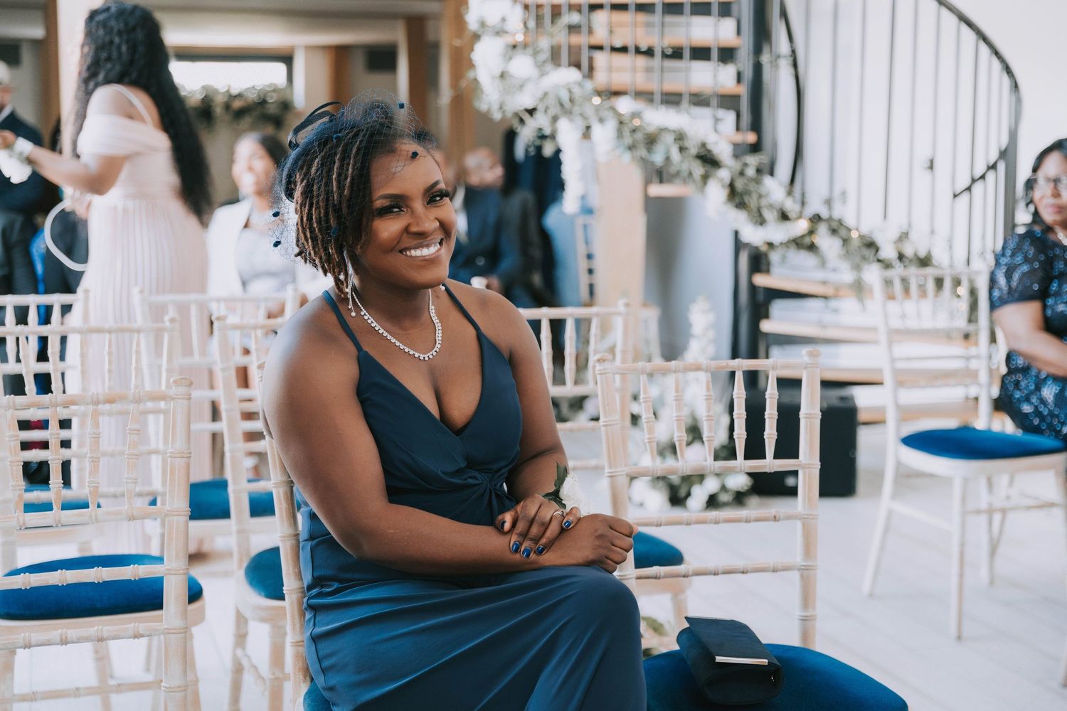 Wedding guests enjoy a festive outdoor reception with white chairs and decorative elements.