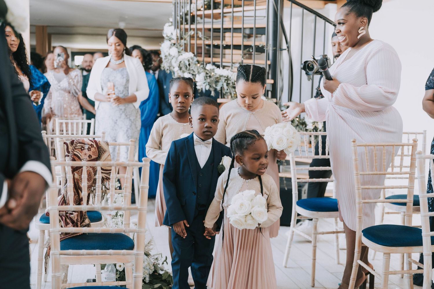 Elegant wedding venue decorated in white and blue with guests mingling.