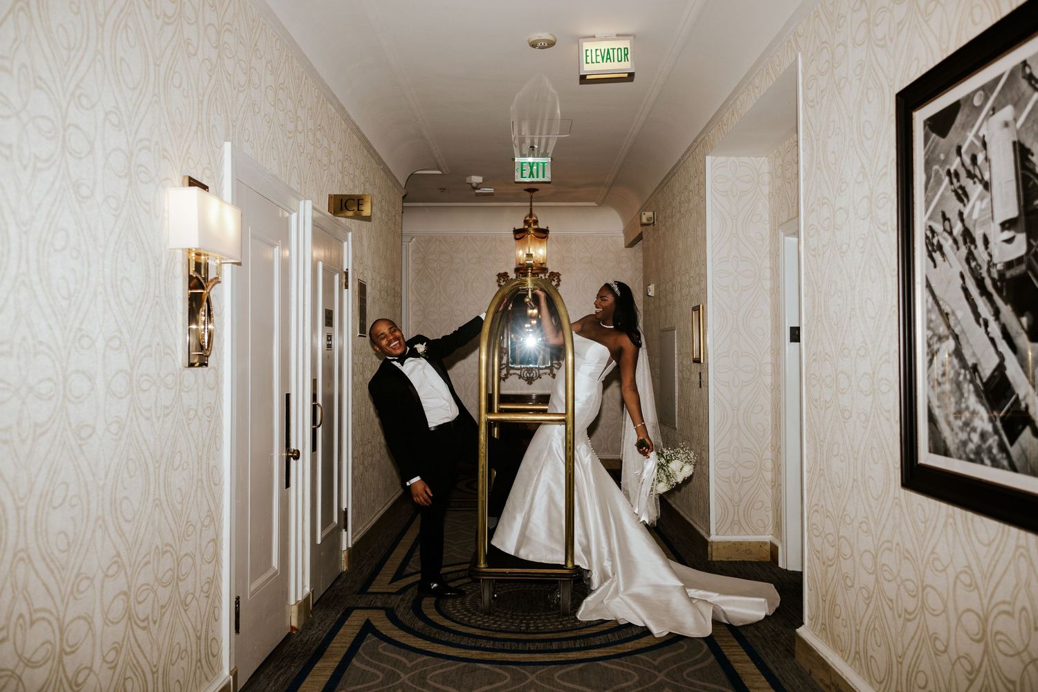 bride and groom hanging off a luggage cart at the Fairmont Hotel on their elopement day in San Francisco