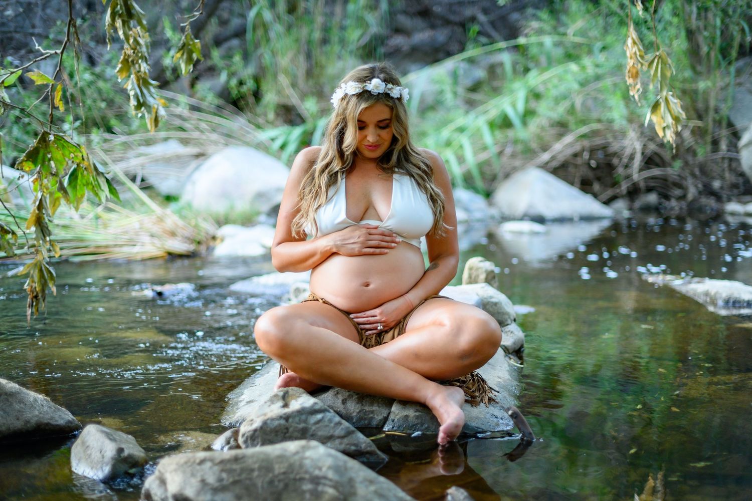 Serene maternity photoshoot of woman sitting by a stream. Maternity photoshoot in Las Vegas. Bohemian maternity photographer Las Vegas.