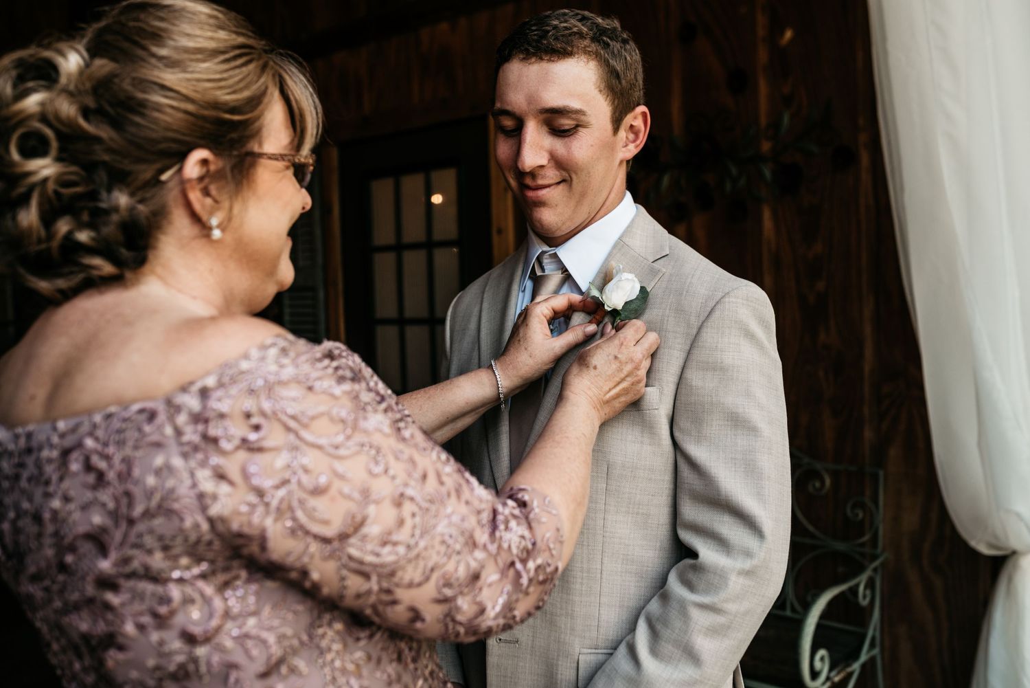 Tender moment of boutonniere pinning before the wedding ceremony.