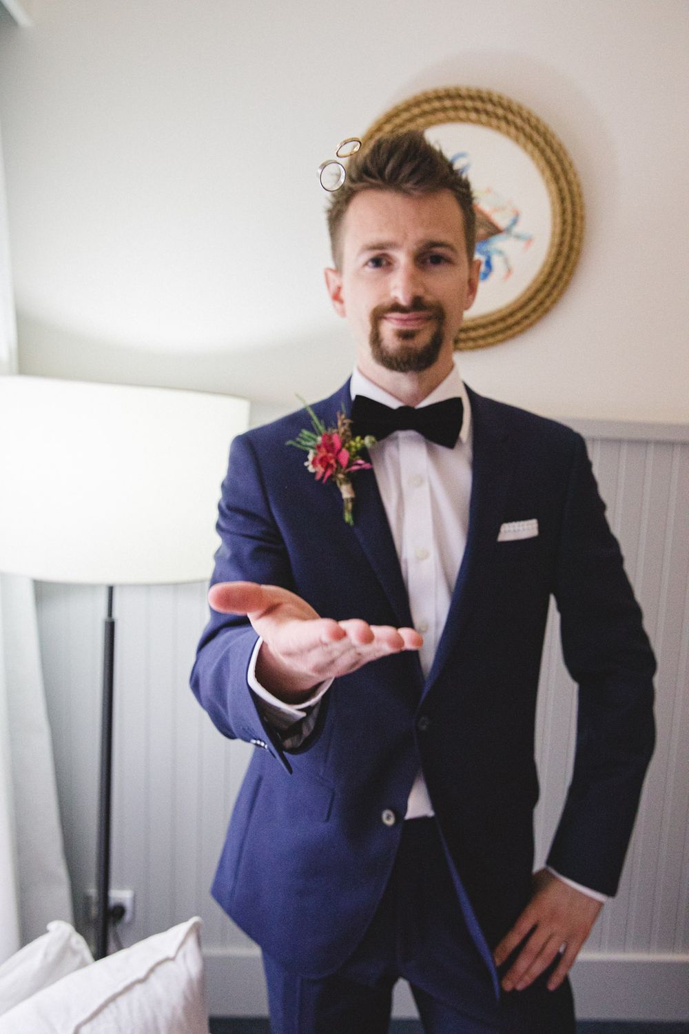 Groomsmen in navy suits and white shirts posing playfully with rings.