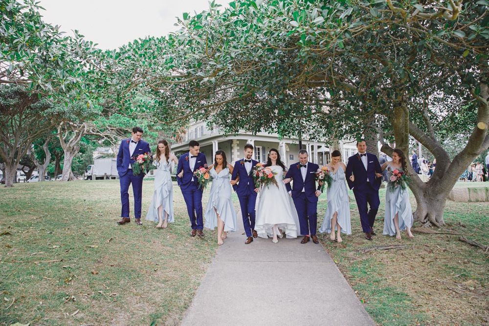 Wedding party walks together across scenic outdoor venue during celebration.