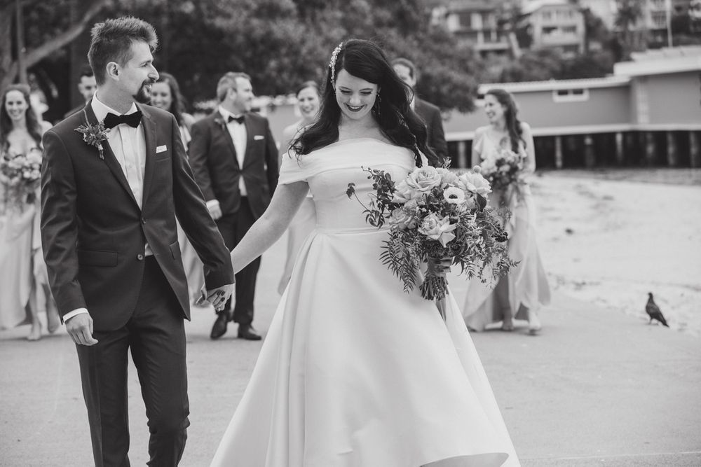Wedding celebration captured in black and white as party walks together outdoors.