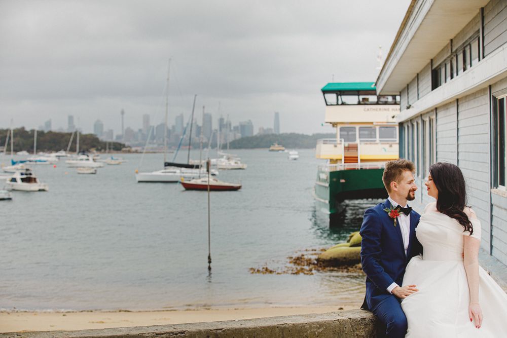 Waterfront wedding photos with harbor and boats in background on overcast day.