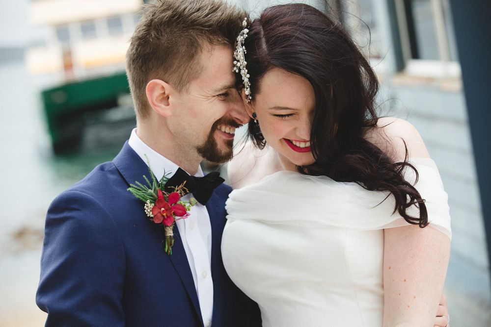 Romantic winter wedding portraits with couple in navy and white against urban backdrop.