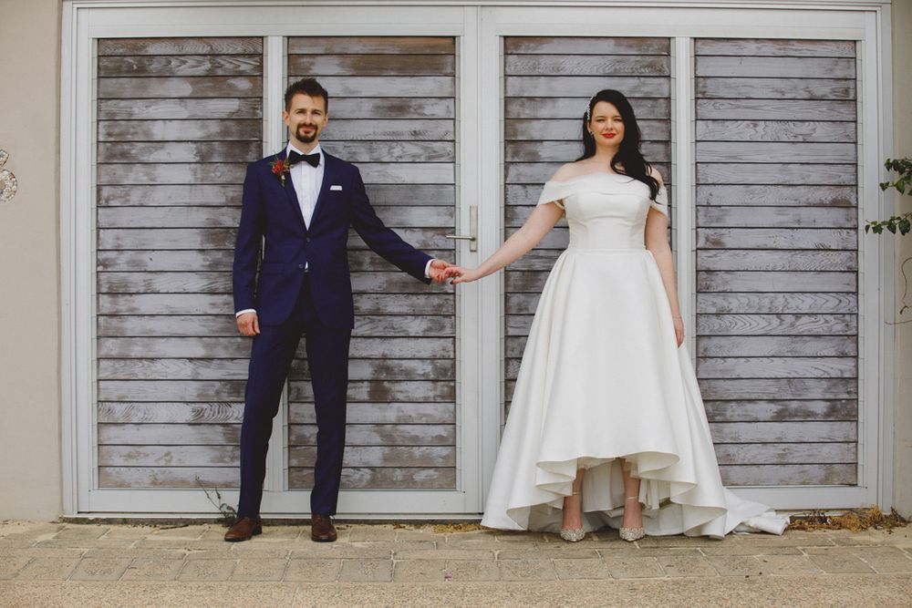 Creative wedding portraits against weathered wooden garage doors.