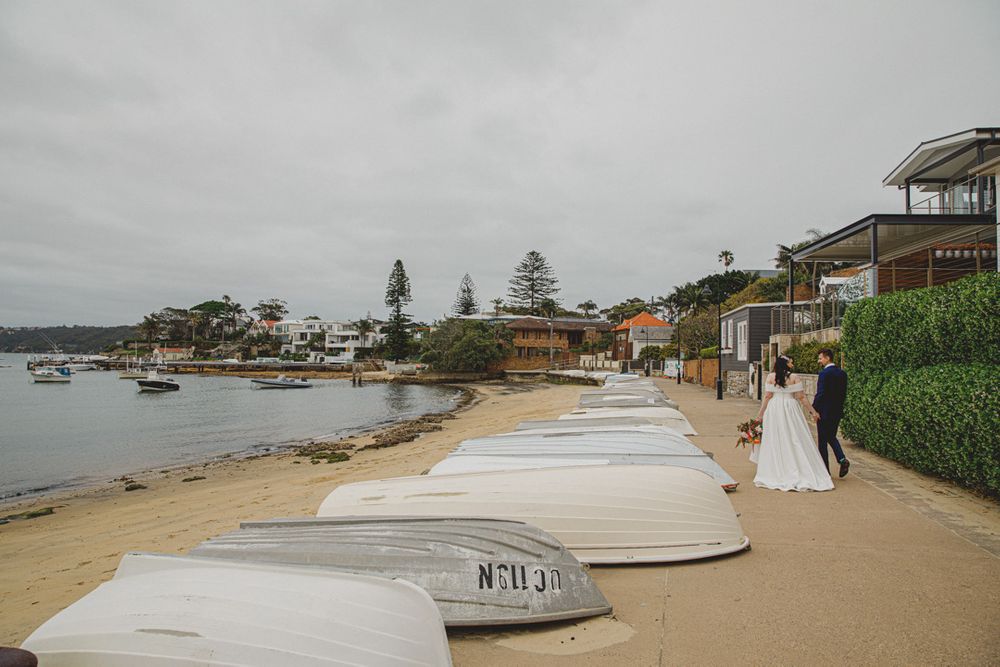 Panoramic view of a beachfront with boats and coastal buildings.