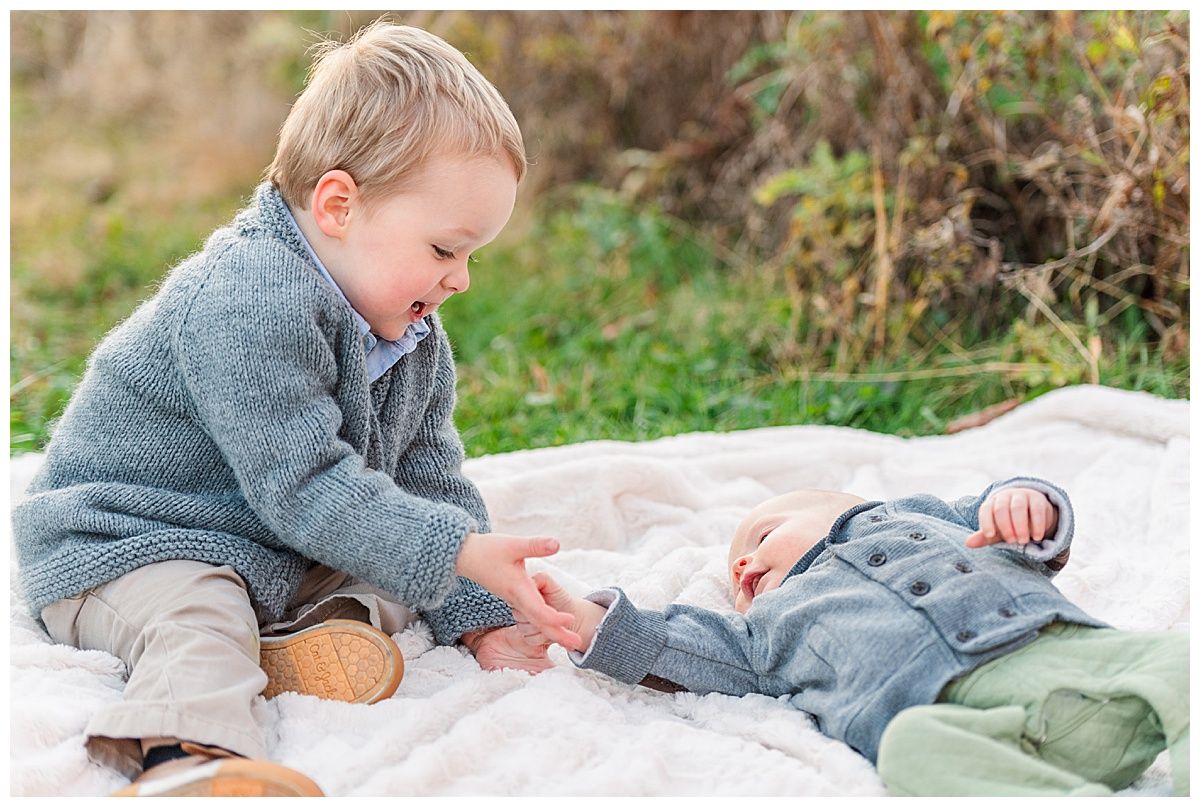 Children's portrait of toddler boy and baby brother on blanket with outfit inspiration