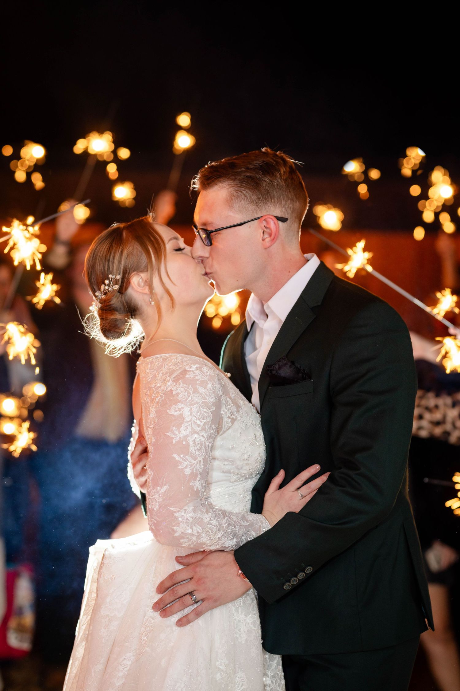 Bride and groom kissing during their sparkler exit at a Fayetteville, Arkansas wedding