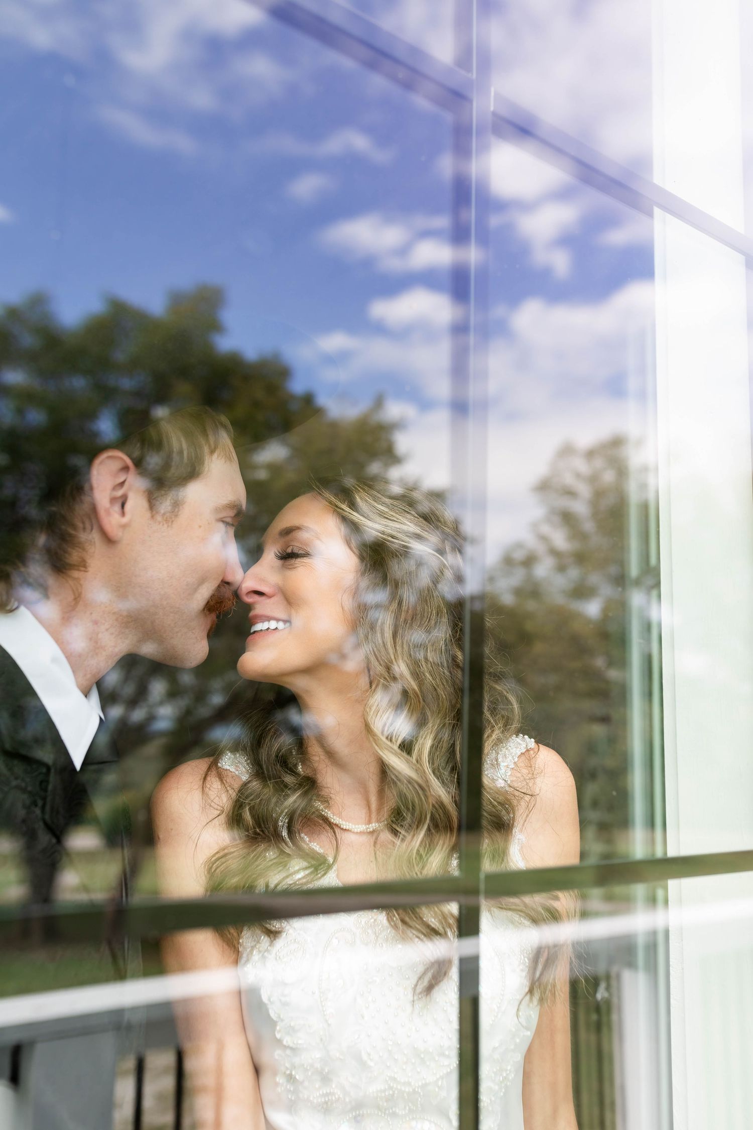 Bride and groom share a close moment at The Elms, Flippin Arkansas, with a reflection capturing their joy.