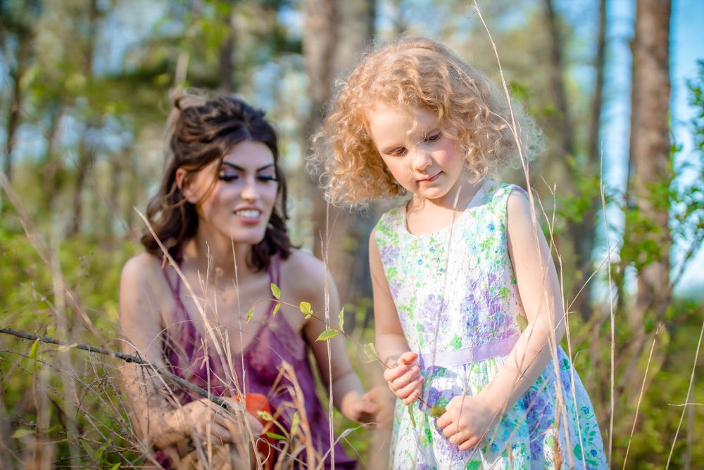 Woman and a young girl playing in the tall grass during an outdoor session near Mountain Home, Arkansas