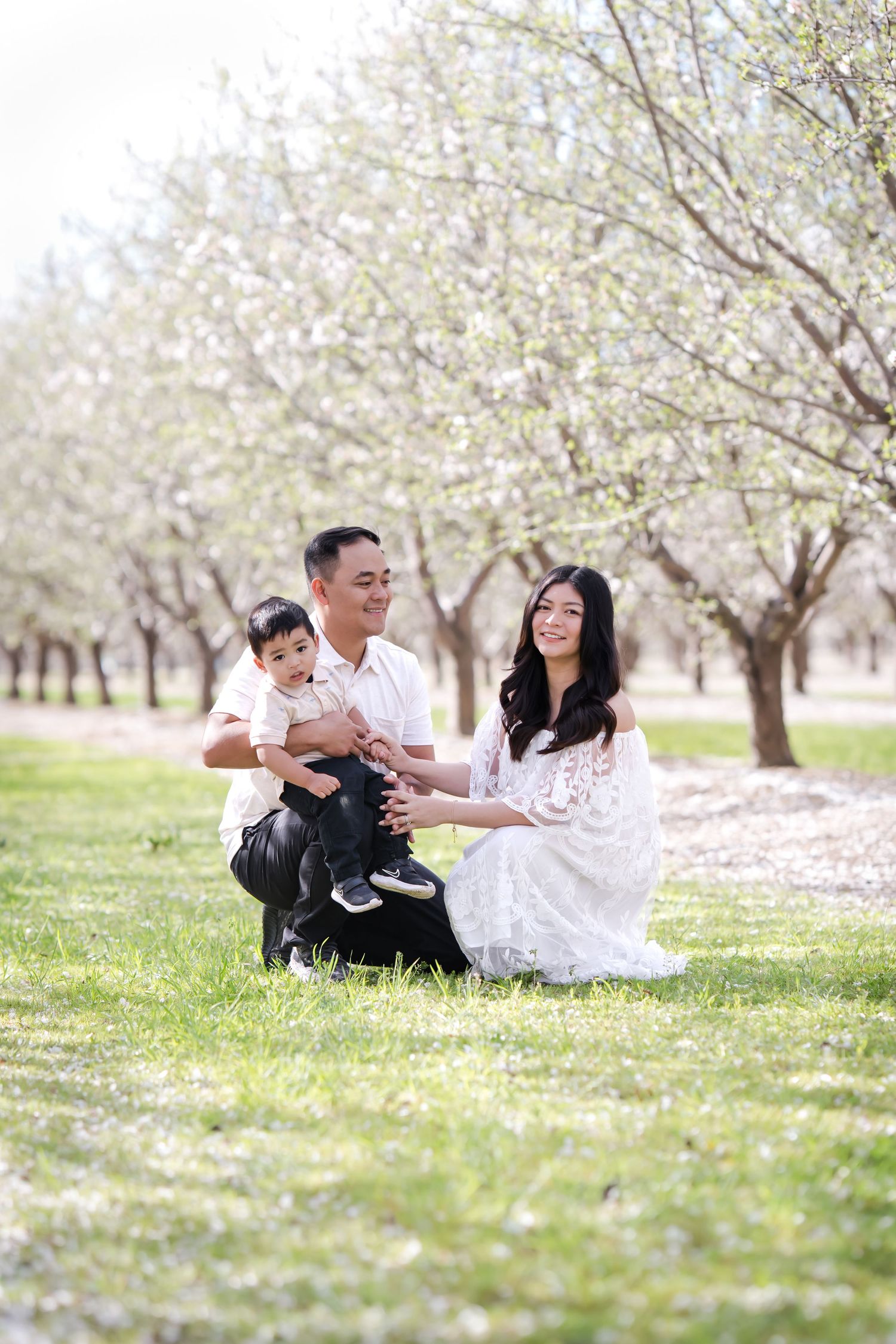 Expecting couple walking hand-in-hand under the cherry blossoms, creating timeless memories during a beautiful maternity photoshoot in Sacra