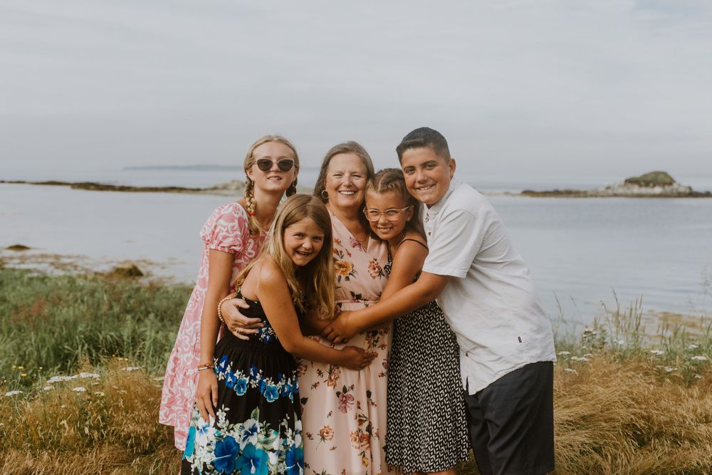 Family hugging by ocean. Photo by Samantha Bateman.