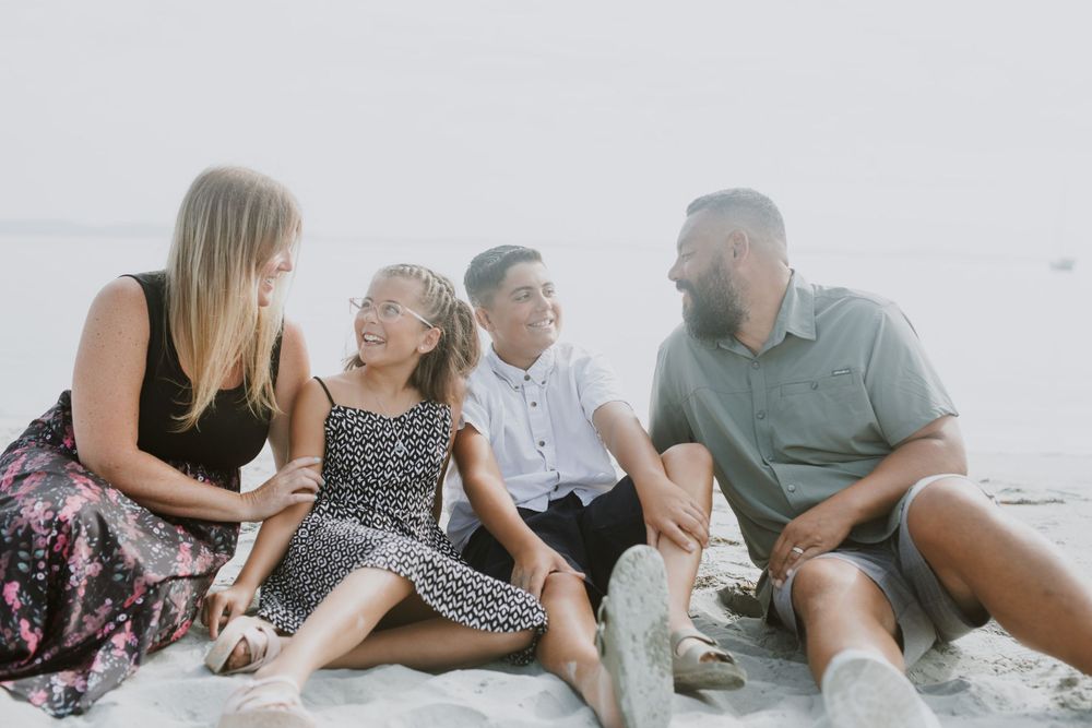 Family sitting on beach. Photo by Samantha Bateman.