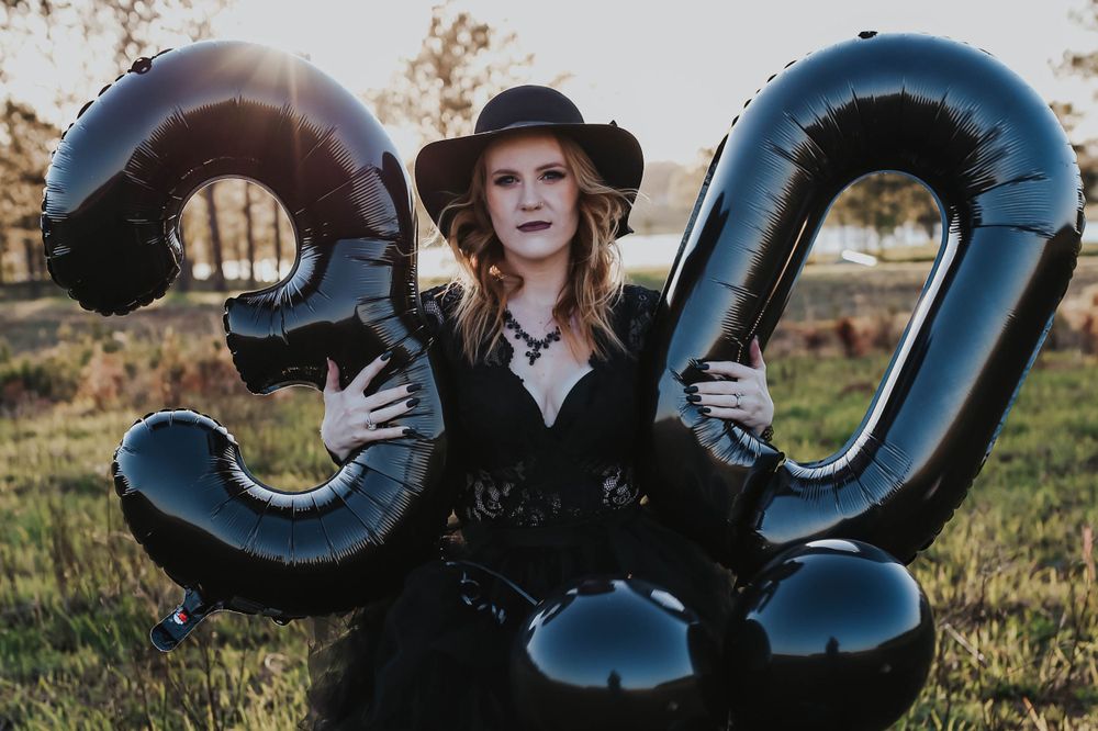 Metallic blue number balloons displayed outdoors during sunset photography session.