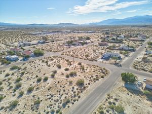 Aerial view of residential desert community with winding roads and scattered houses.