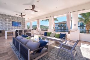 Covered outdoor living space with blue sectional seating and coastal-inspired decor.
