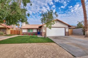 Single-story ranch home with two-car garage, desert landscaping, and fresh exterior paint.