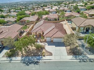 Aerial view of a suburban neighborhood with Spanish-style homes featuring terracotta roofs and desert landscaping.