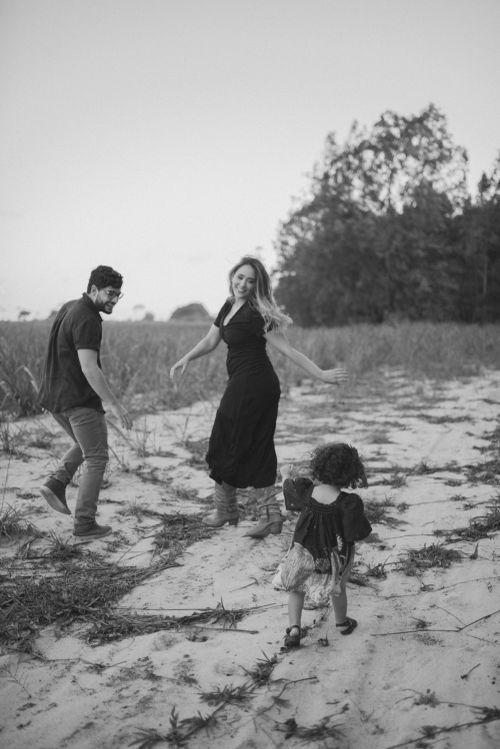 A family enjoying a carefree moment together while walking on sandy terrain.