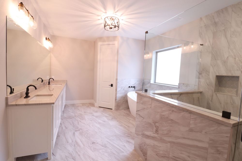 Spacious master bathroom featuring double vanity, freestanding tub, and marble tile flooring.