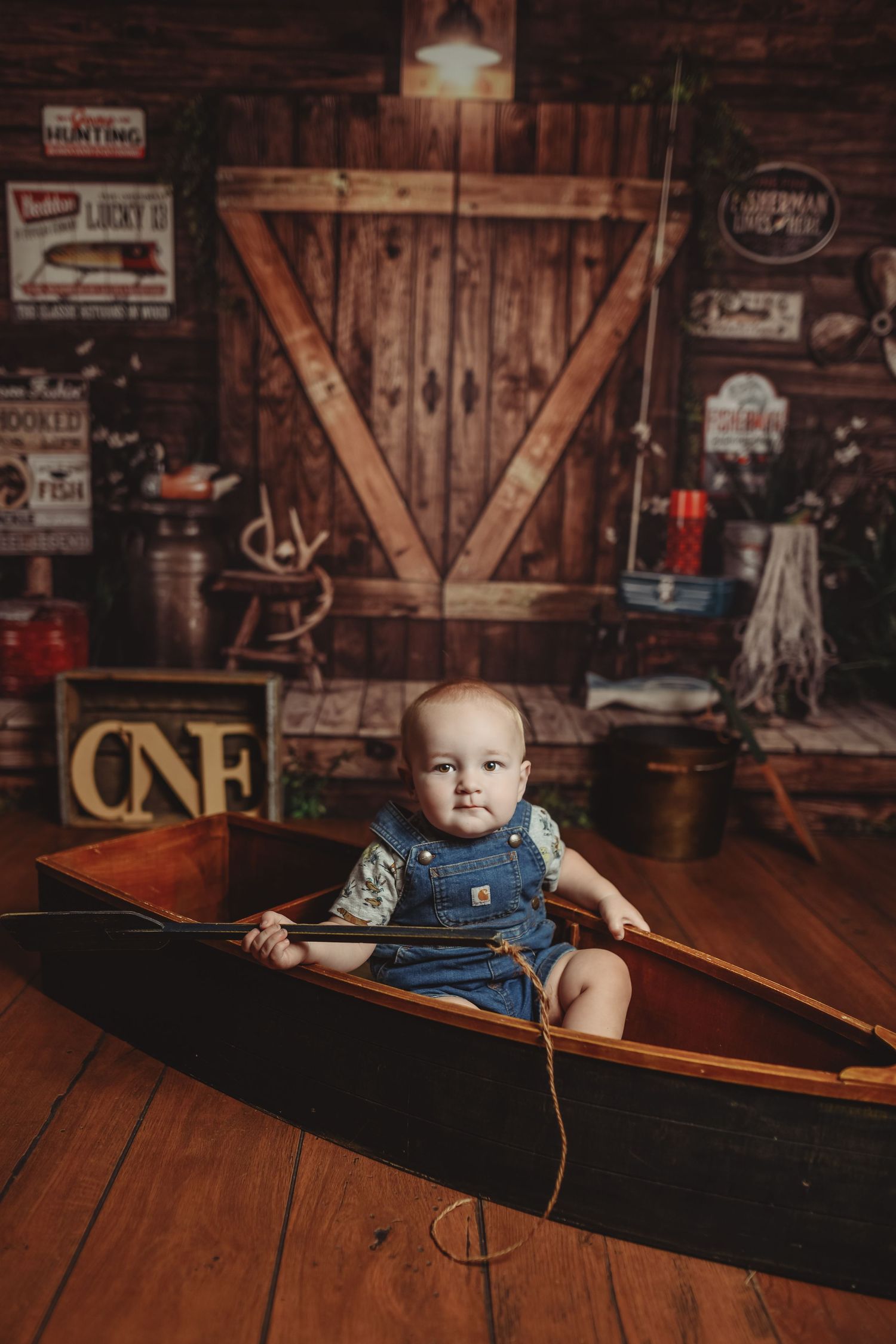 Rustic barn interior with wooden floors and vintage signs on wall.
