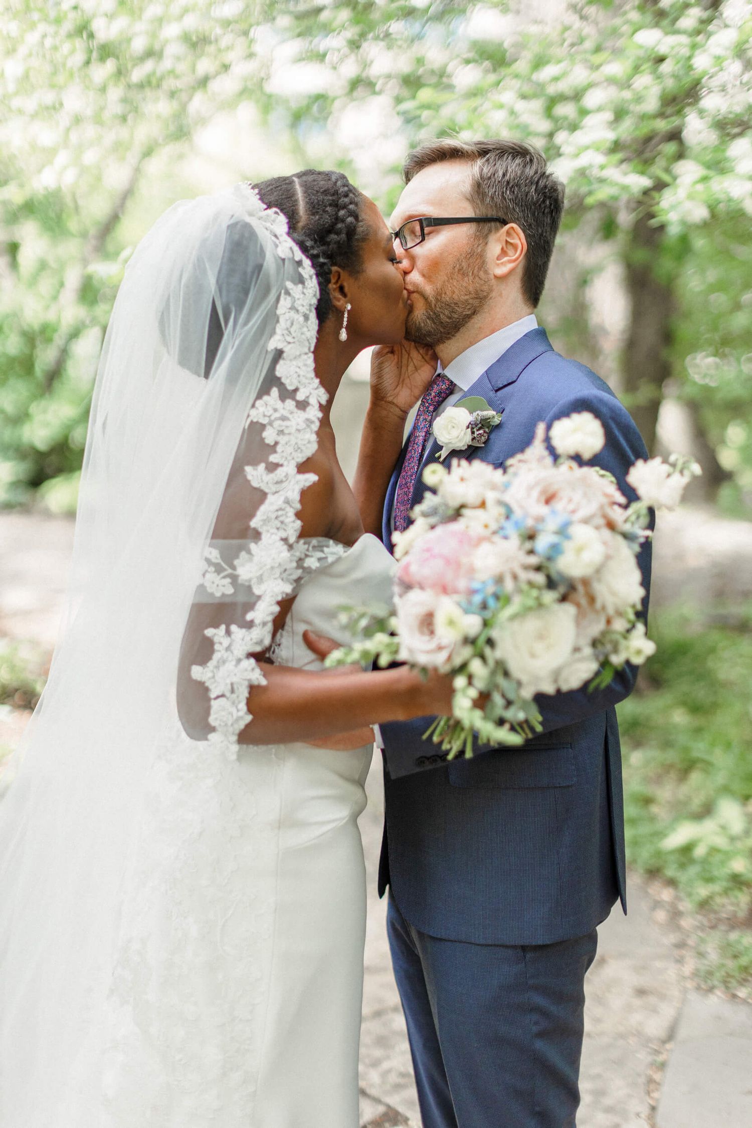 Wedding couple sharing an intimate moment in a garden setting with soft lighting.