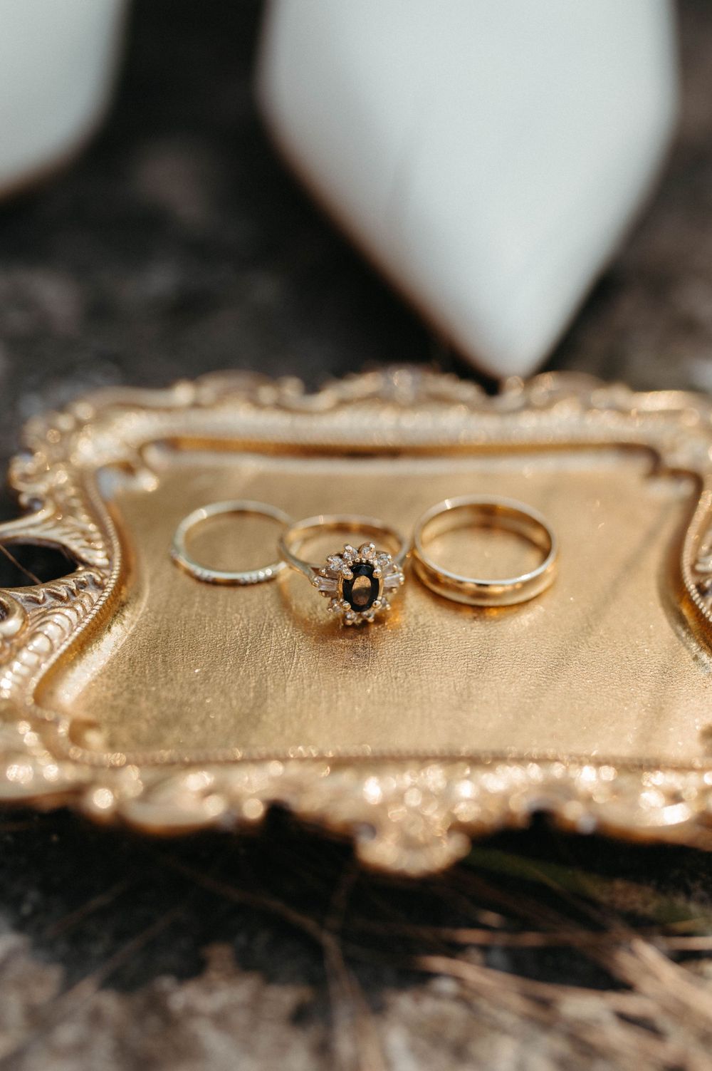 Wedding rings including diamond engagement ring displayed on vintage gold decorative tray.