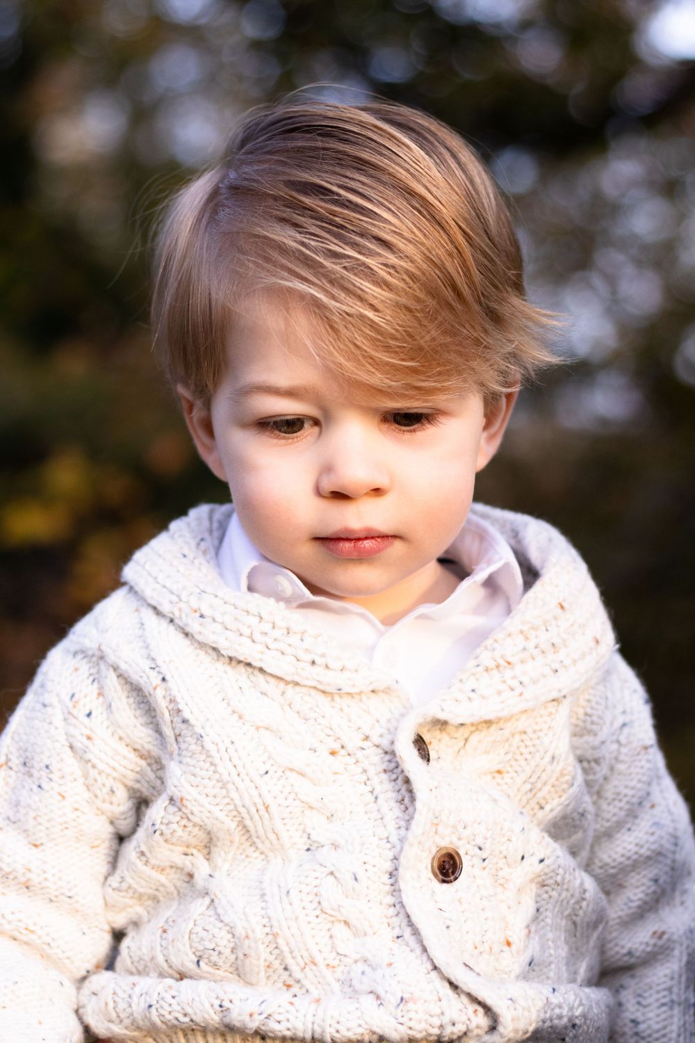 A boy toddler looks down