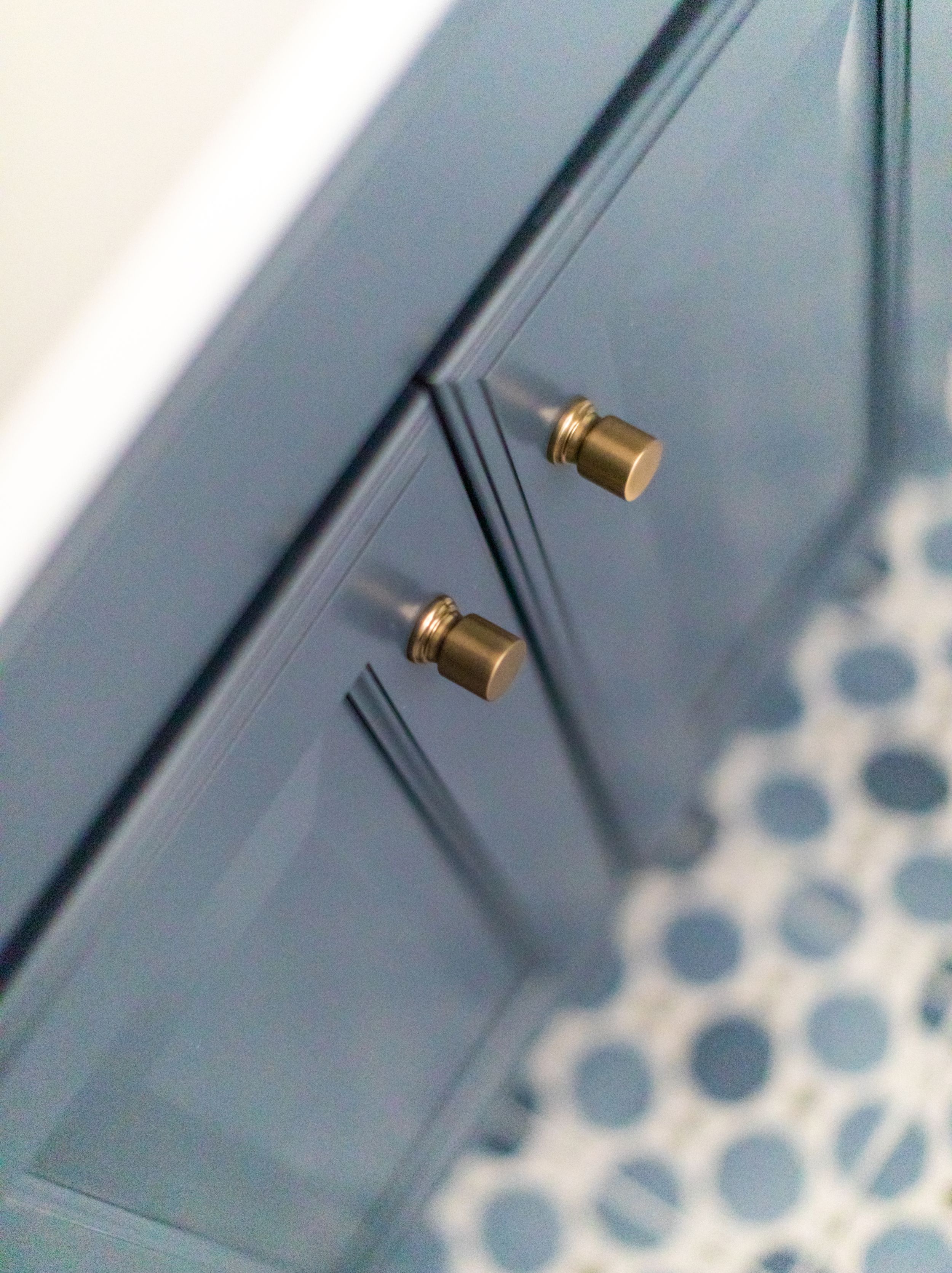 Blue coastal bathroom with gold hardware and mosaic tiling