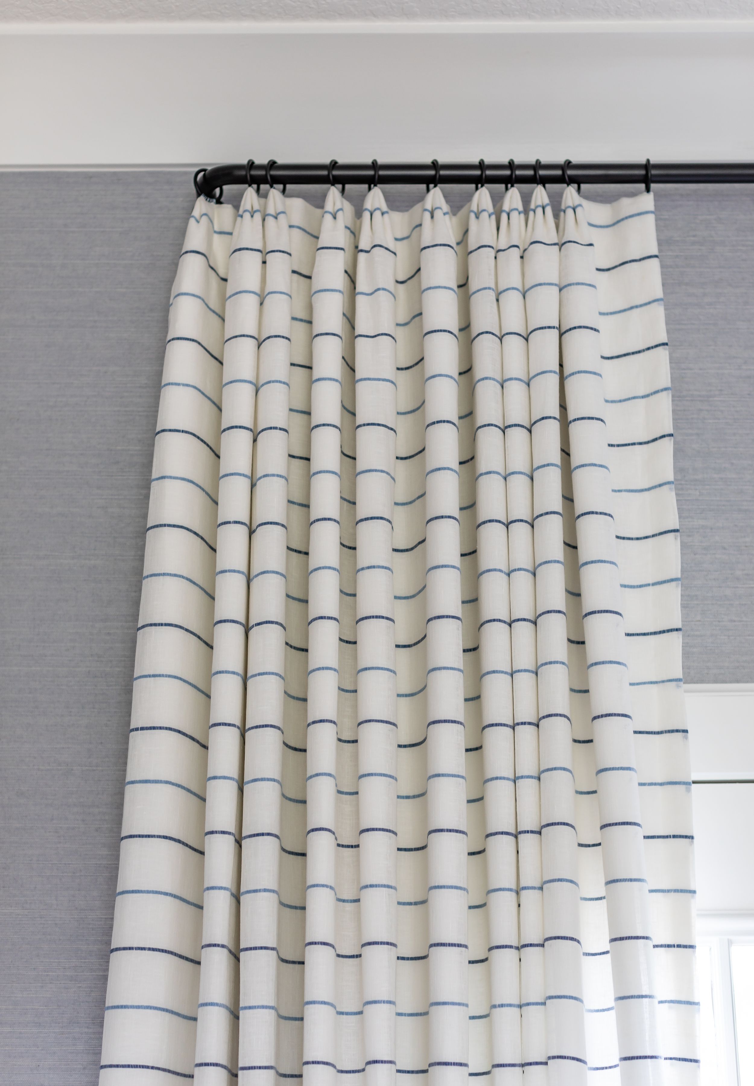 Custom curtains layered over Phillip Jeffries grey wall covering
