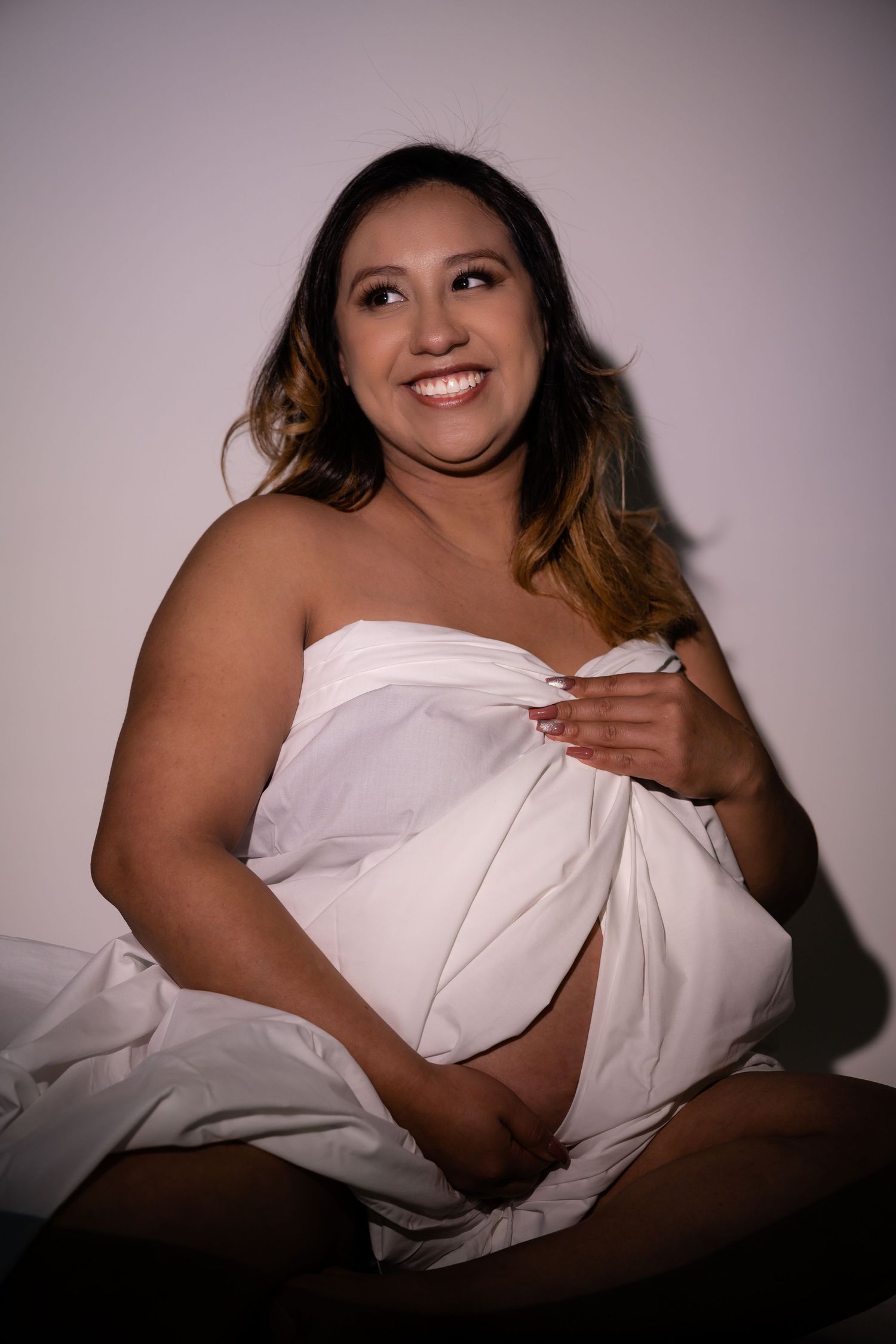 Artistic boudoir photography series featuring white sheets and dramatic lighting against a dark background.