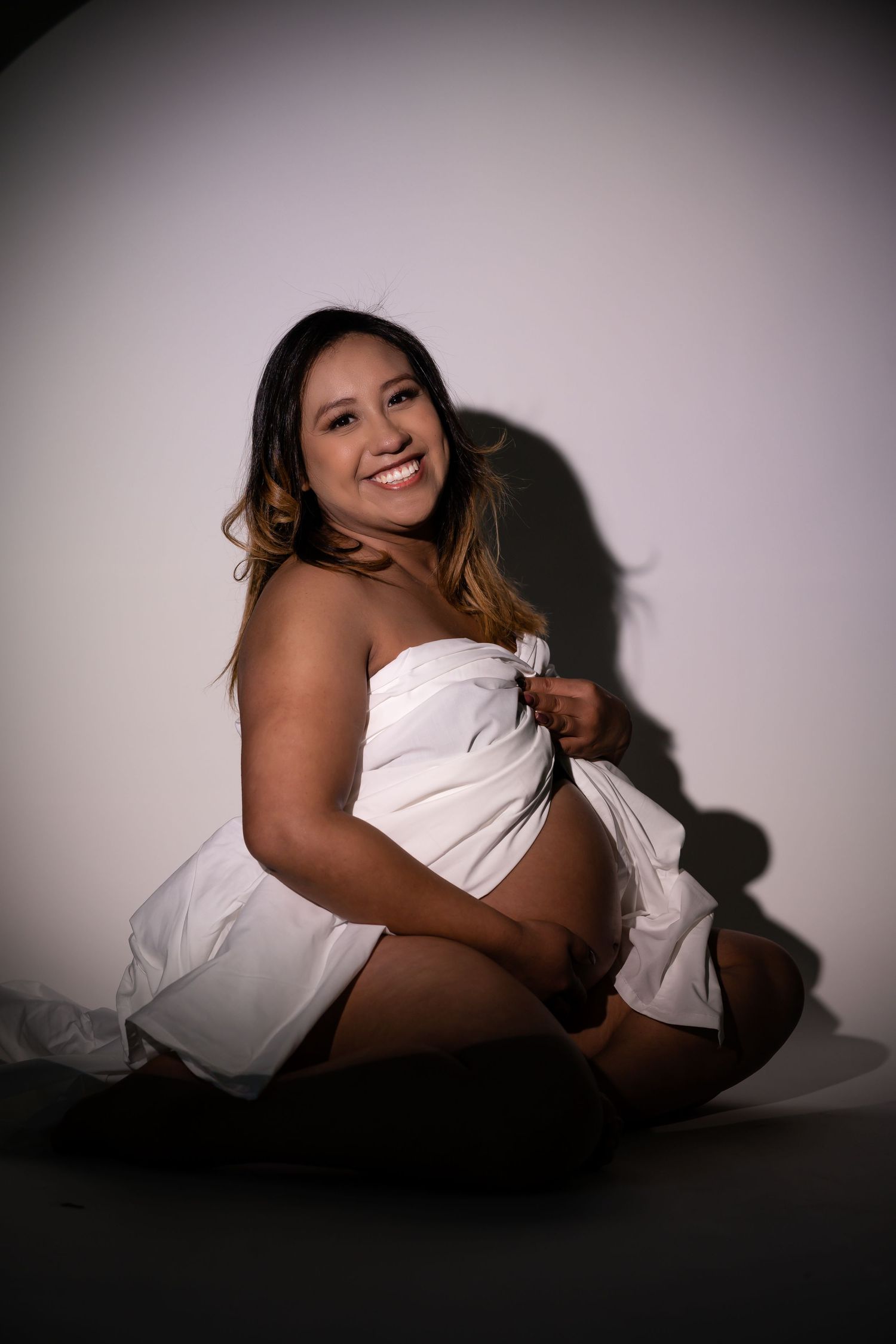 Intimate studio portraits with soft lighting and white fabric creating elegant shadows.