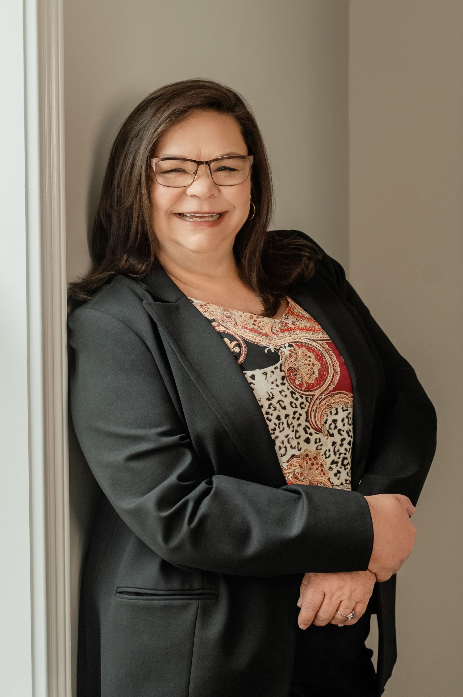 Professional headshot of a woman with glasses in natural light, perfect for LinkedIn profile or corporate branding.